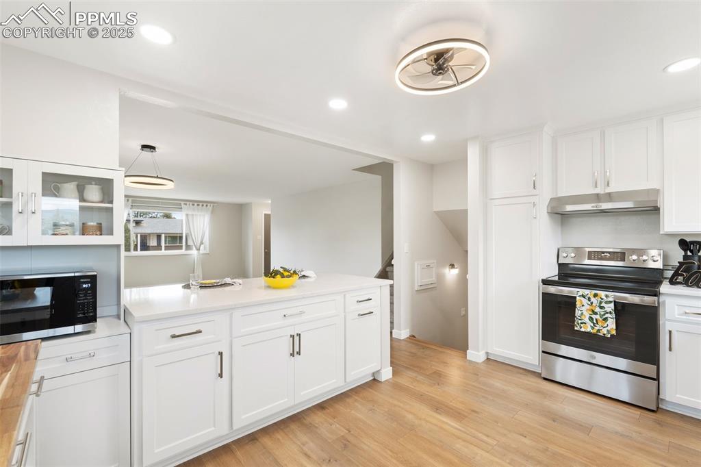 Image 8 of 50: Large island/counter bar with extra cabinet space! And the built-in microwa