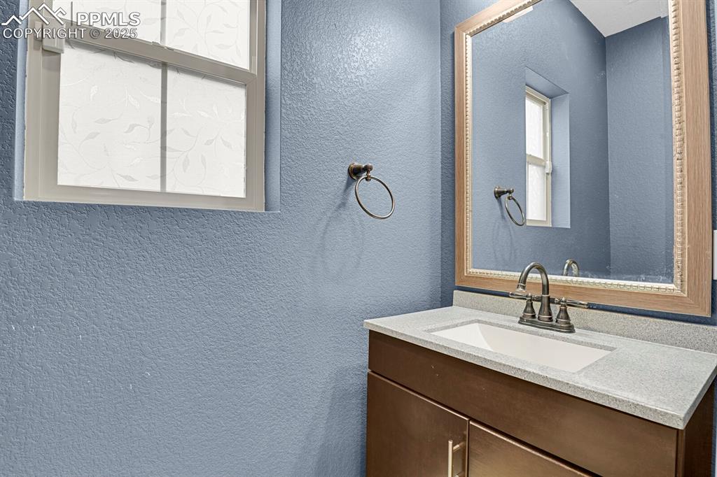 Image 12 of 30: Bathroom with a textured wall and vanity