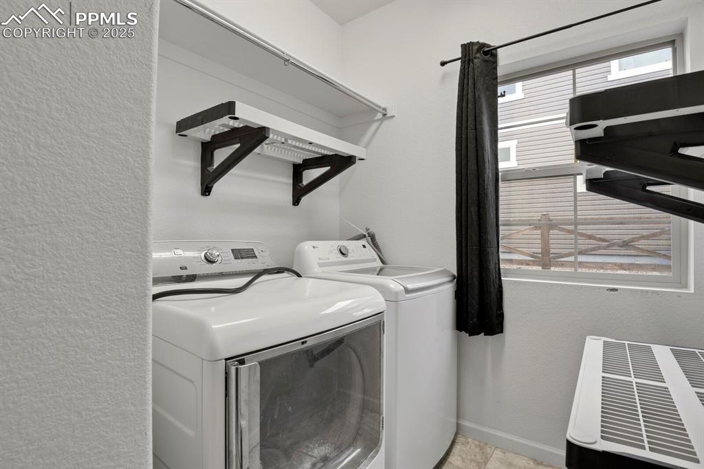 Image 13 of 30: Laundry area with a textured wall and washing machine and dryer