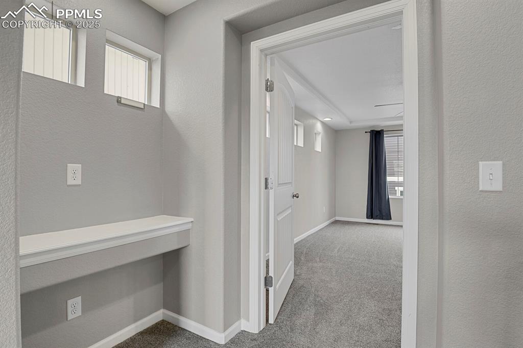 Image 16 of 30: Corridor featuring light colored carpet and a textured wall