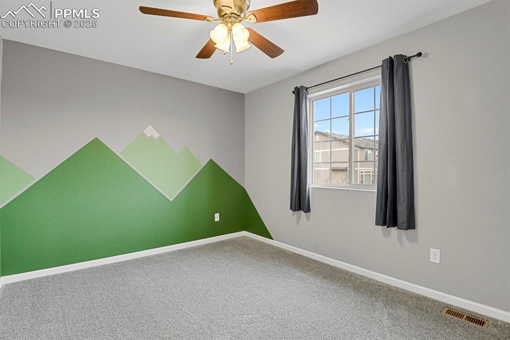 Image 20 of 30: Spare room featuring carpet and a ceiling fan