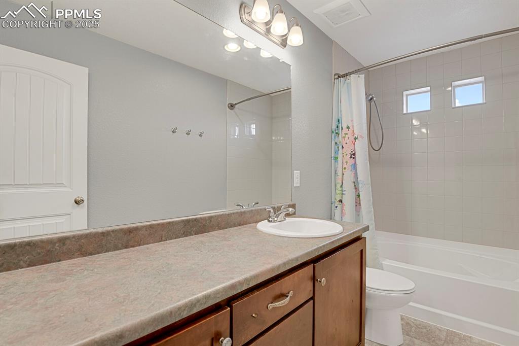 Image 21 of 30: Bathroom featuring vanity, shower / bath combination with curtain, and ligh