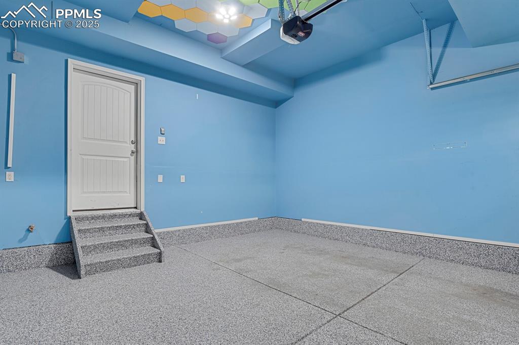 Image 24 of 30: Garage featuring epoxy flooring.