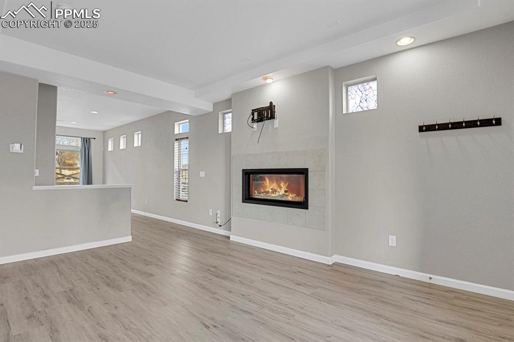 Image 28 of 30: Unfurnished living room featuring recessed lighting, a fireplace, healthy a