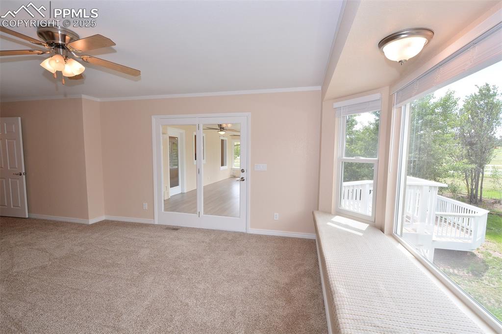 Image 18 of 50: Master bedroom window seat with deck view