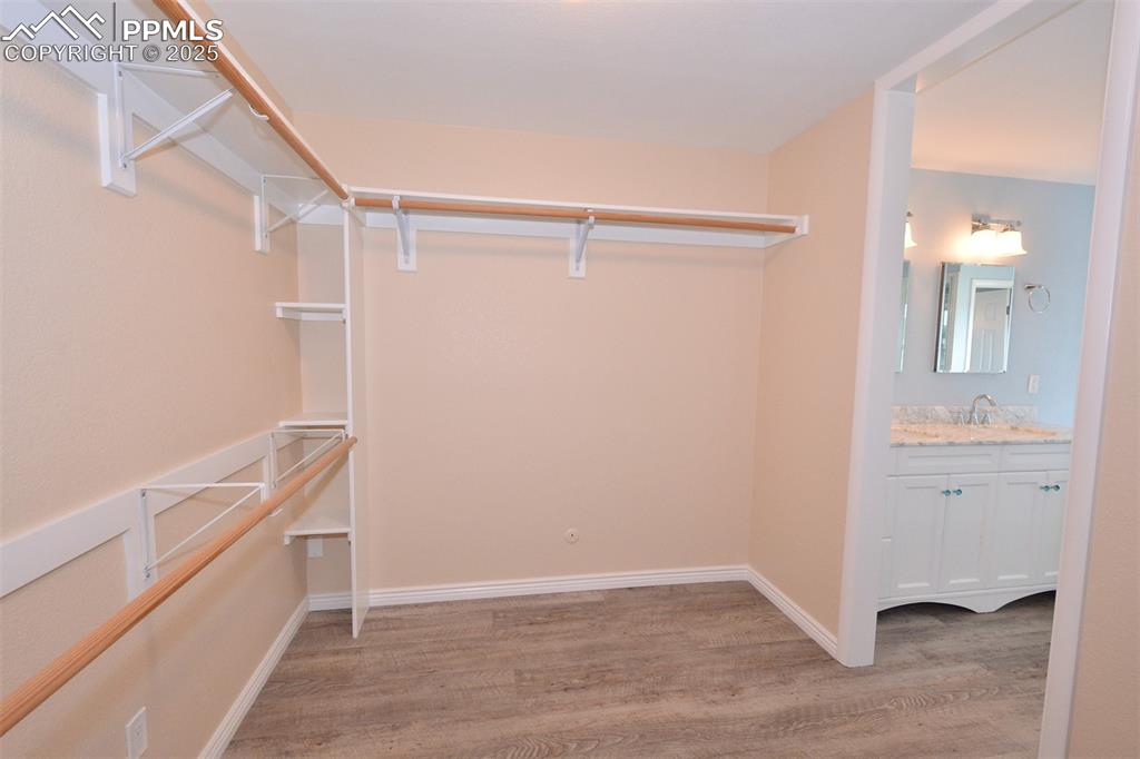 Image 19 of 50: Spacious walk-in master bedroom closet between the bedroom and bathroom ent