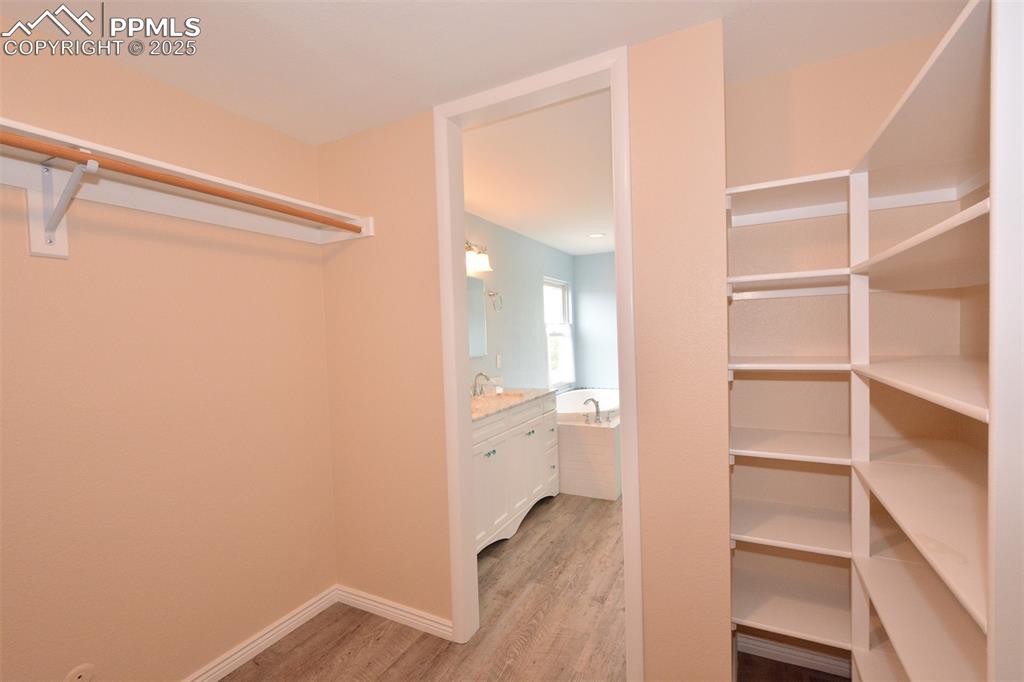Image 20 of 50: Master bedroom closet has some shelf space too