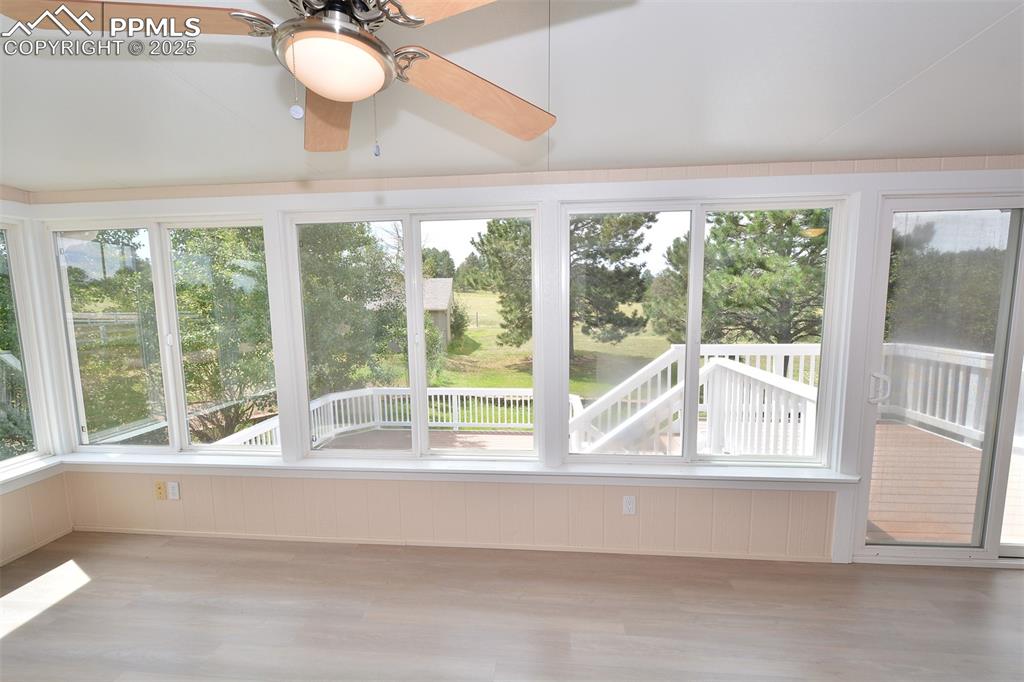 Image 30 of 50: Sunroom with deck and backyard view