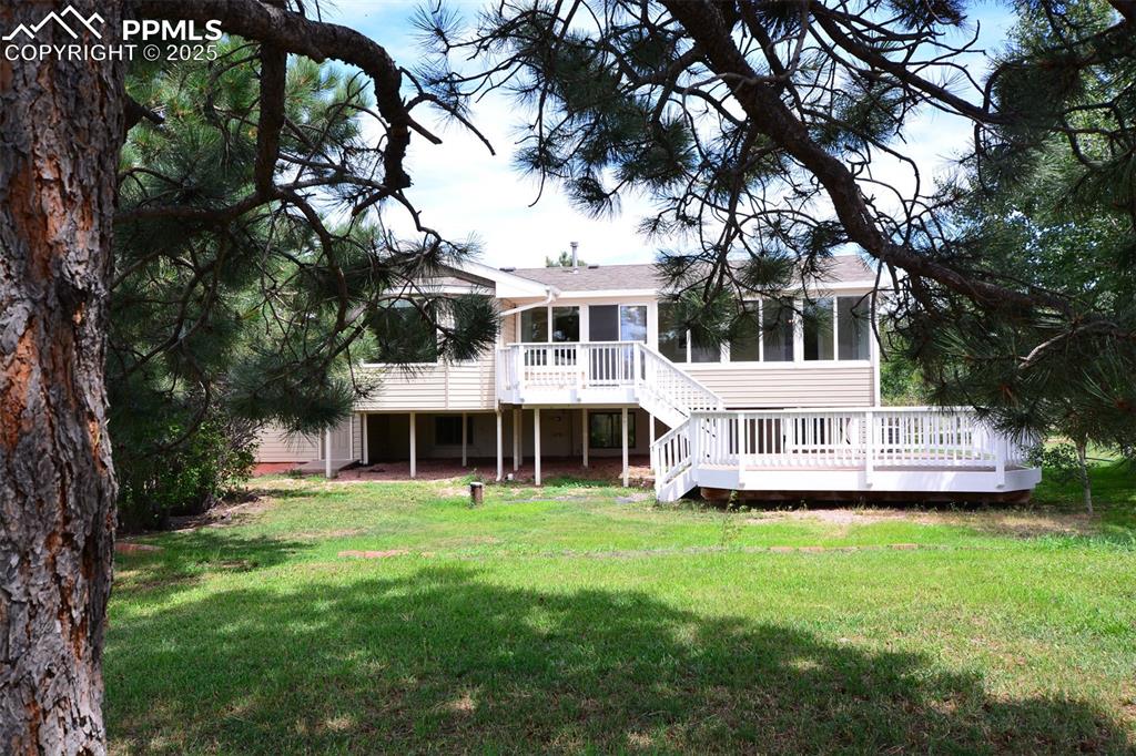 Image 50 of 50: Back side of home with mature trees
