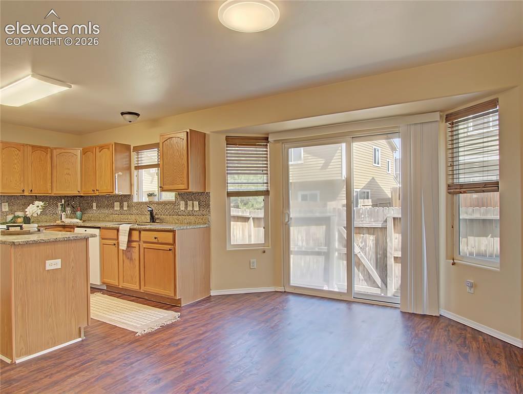 Image 11 of 28: Kitchen dining area featuring wood-finish flooring, a sliding glass door, a
