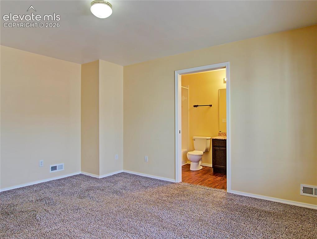 Image 12 of 28: Carpeted room with light-toned walls and white trim