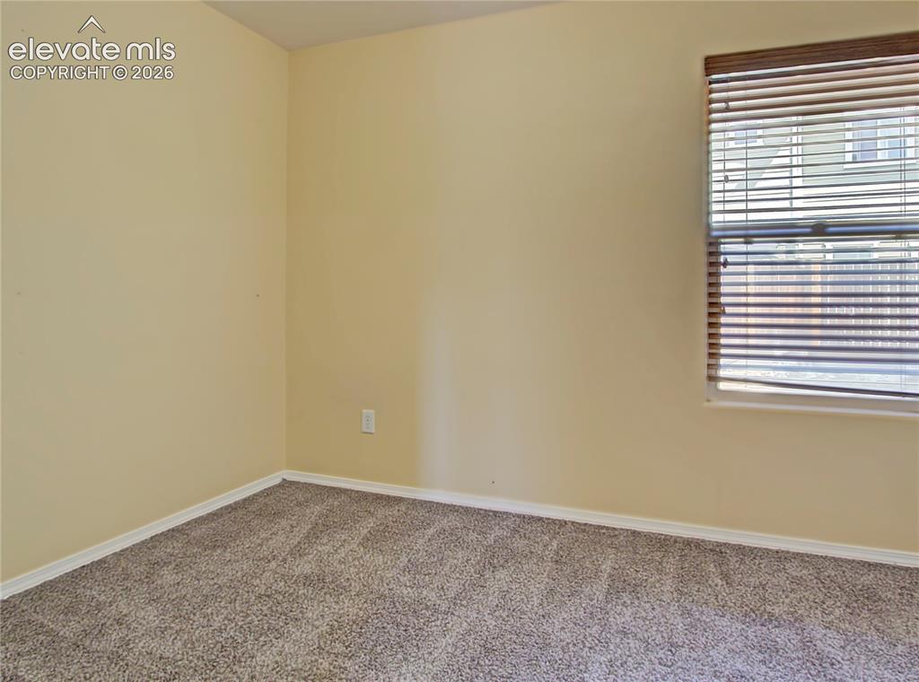 Image 17 of 28: Carpeted room with a window featuring horizontal blinds