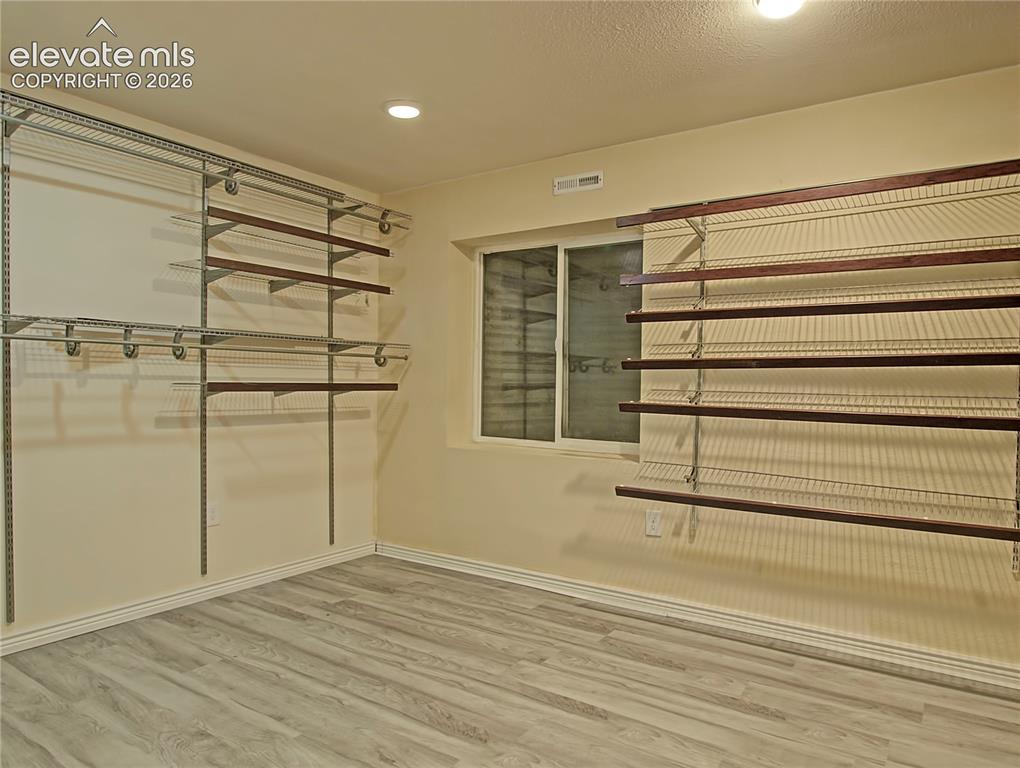 Image 24 of 28: Customizable closet system with wire shelving and wood-finish accents, prov
