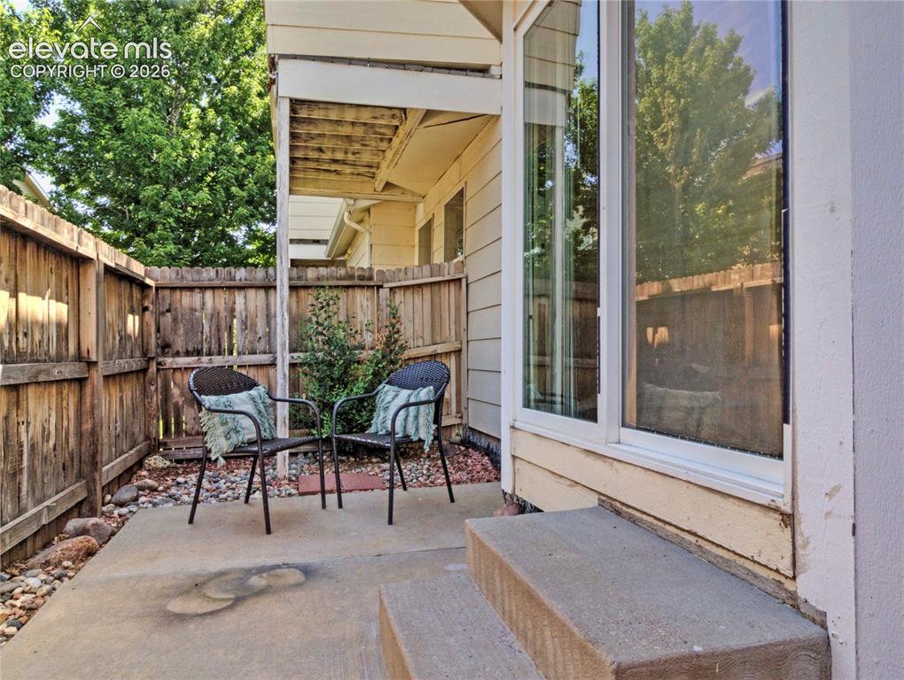 Image 25 of 28: Private patio area featuring a concrete surface, surrounding wood fencing,