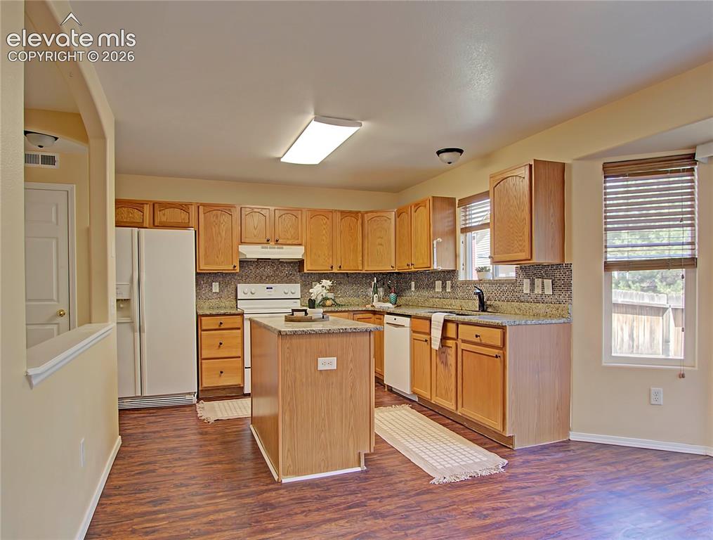 Image 8 of 28: Kitchen featuring wood-finish flooring, light wood cabinetry, white applian