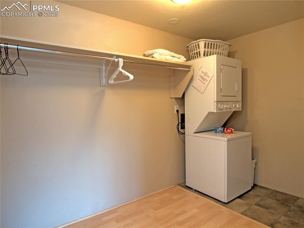 Image 10 of 15: large walk in closet with stackable washer and dryer.