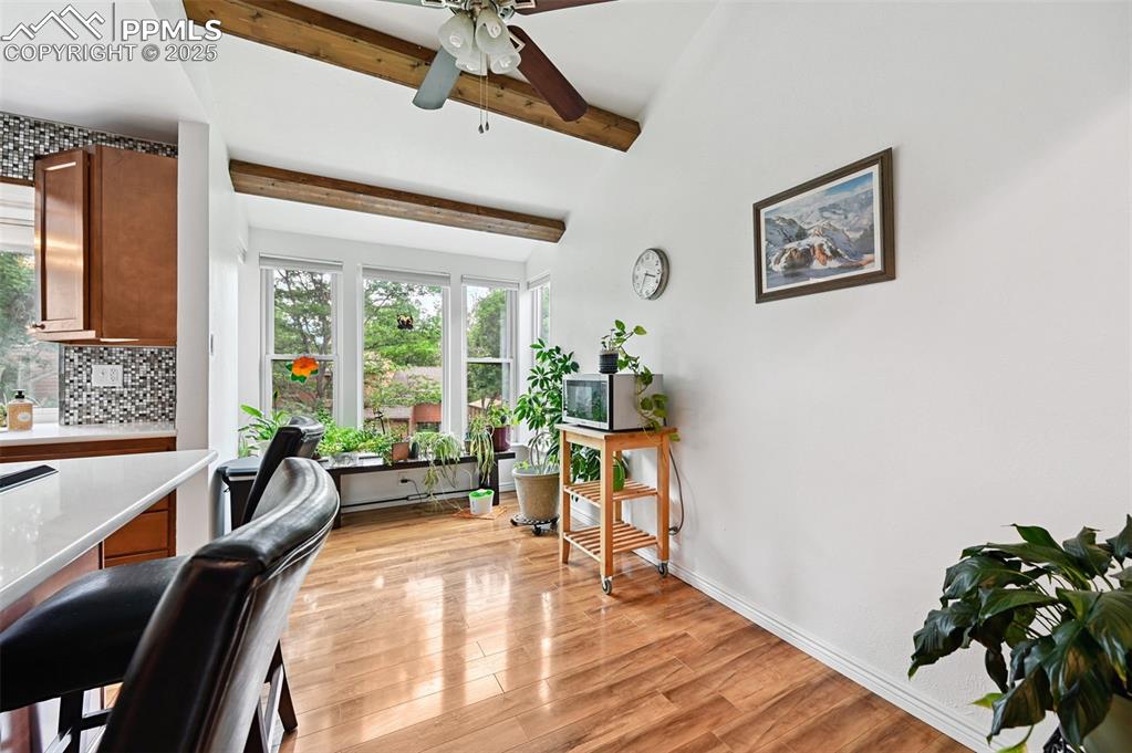 Image 7 of 42: Dining area with large window and wood-stained beams for extra charm.