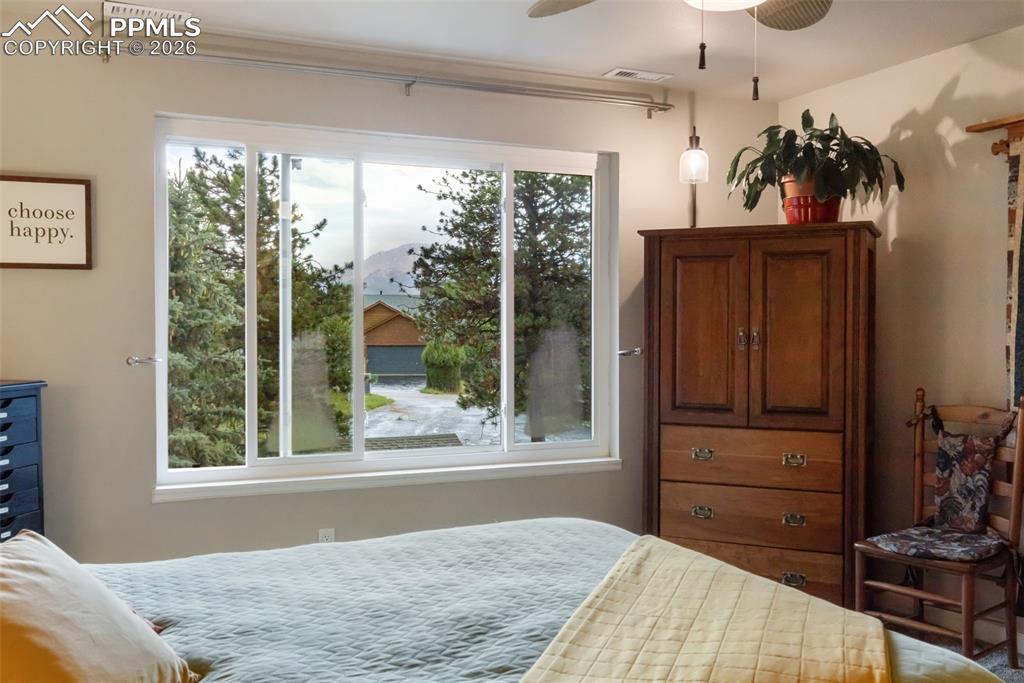 Image 15 of 34: View of Pikes Peak out the primary bedroom window (photo taken during rains