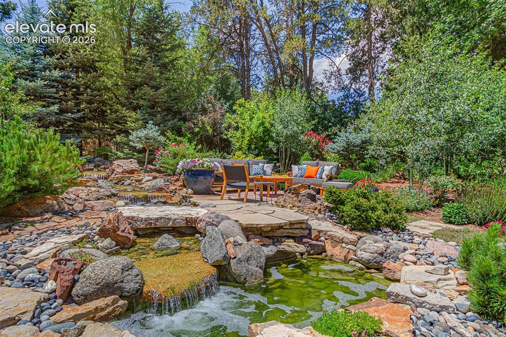 Image 17 of 50: Sit next to the waterfall and enjoy the gardens.