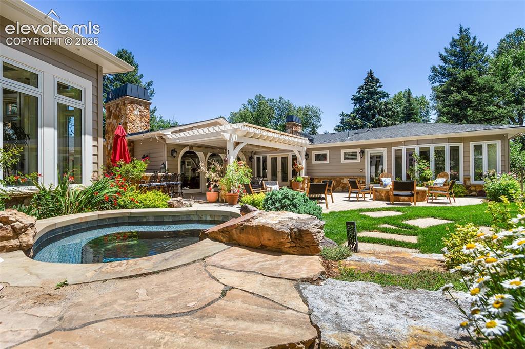 Image 20 of 50: Hot tub, gas fire pit, waterfall feature, and grilling area.