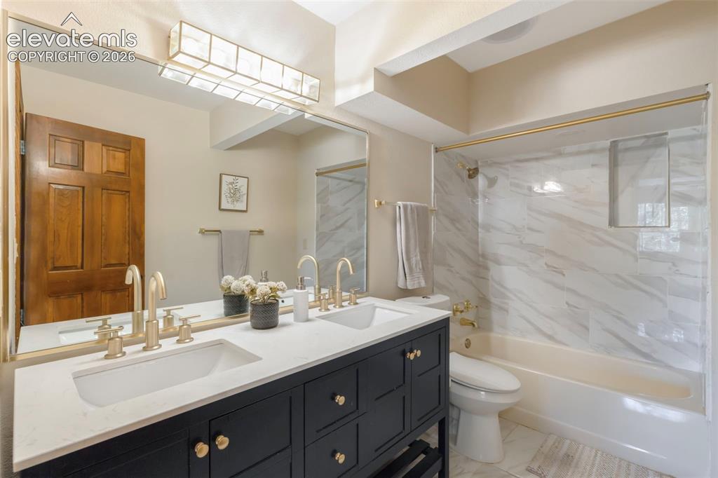 Image 40 of 46: Dual vanity with integrated sinks and gold-tone hardware