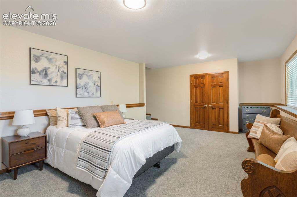 Image 41 of 46: Spacious room featuring light neutral wall tones, plush gray carpeting, bui