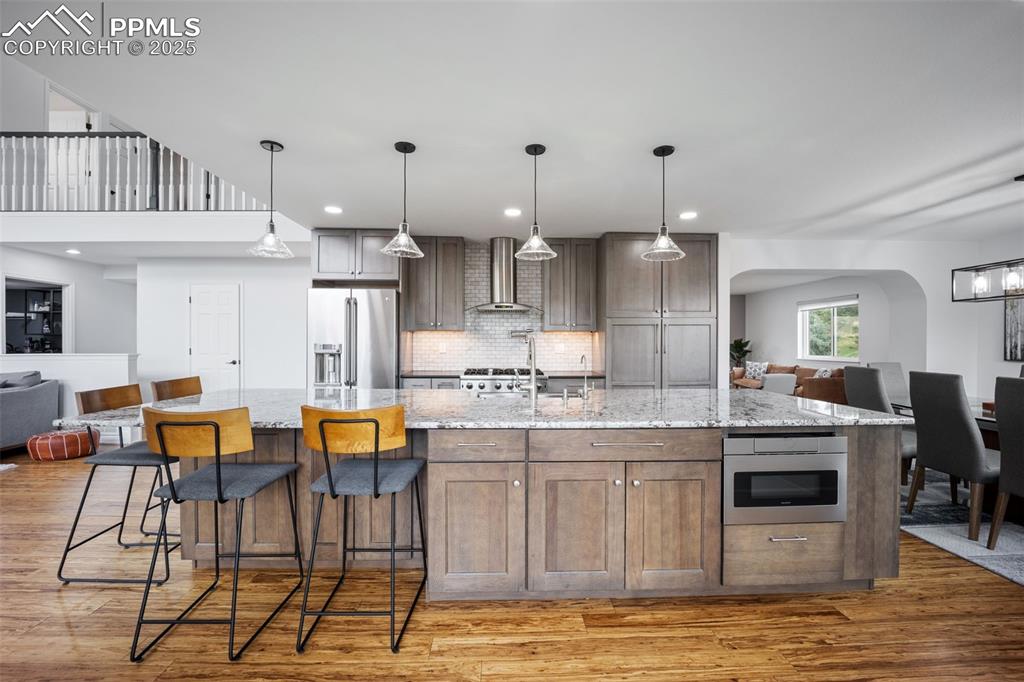 Image 10 of 44: Kitchen featuring open floor plan, recessed lighting, light wood-style floo