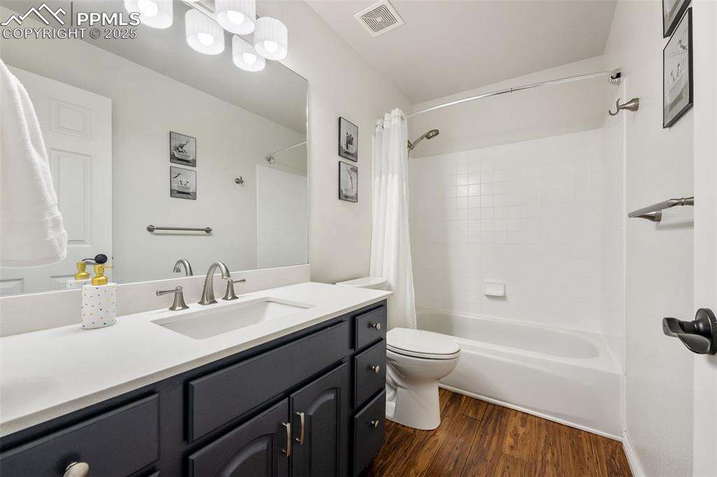Image 15 of 44: Full bathroom with shower / bath combination with curtain, vanity, and wood