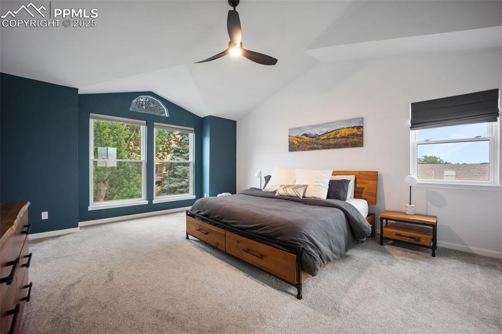 Image 20 of 44: Carpeted bedroom with lofted ceiling and a ceiling fan