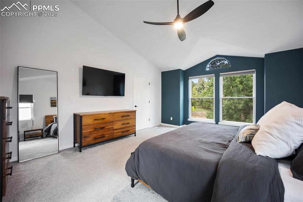Image 22 of 44: Bedroom with lofted ceiling, light colored carpet, and a ceiling fan