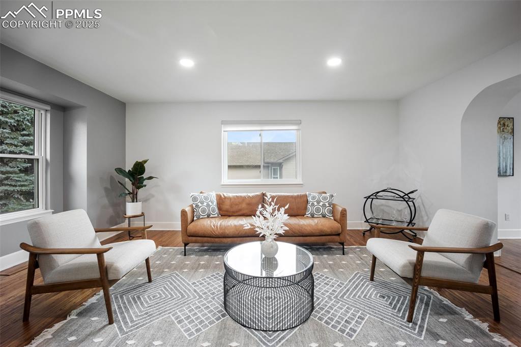 Image 3 of 44: Living area featuring arched walkways, wood finished floors, and recessed l