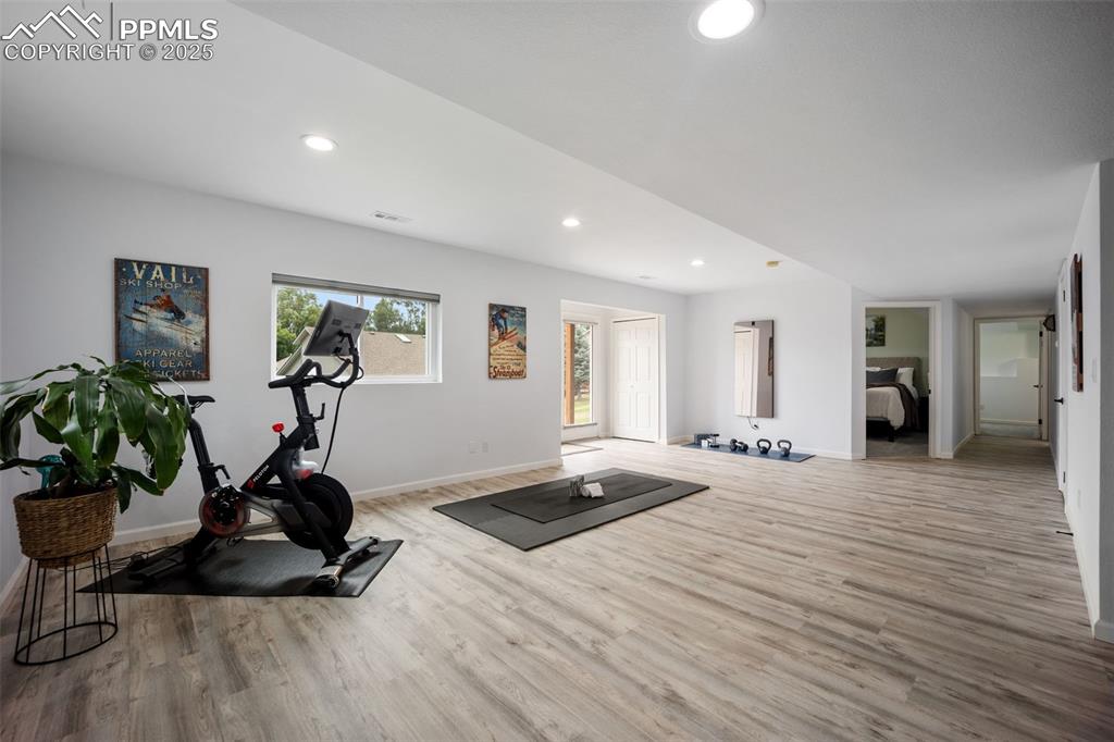 Image 32 of 44: Workout area with wood finished floors and recessed lighting
