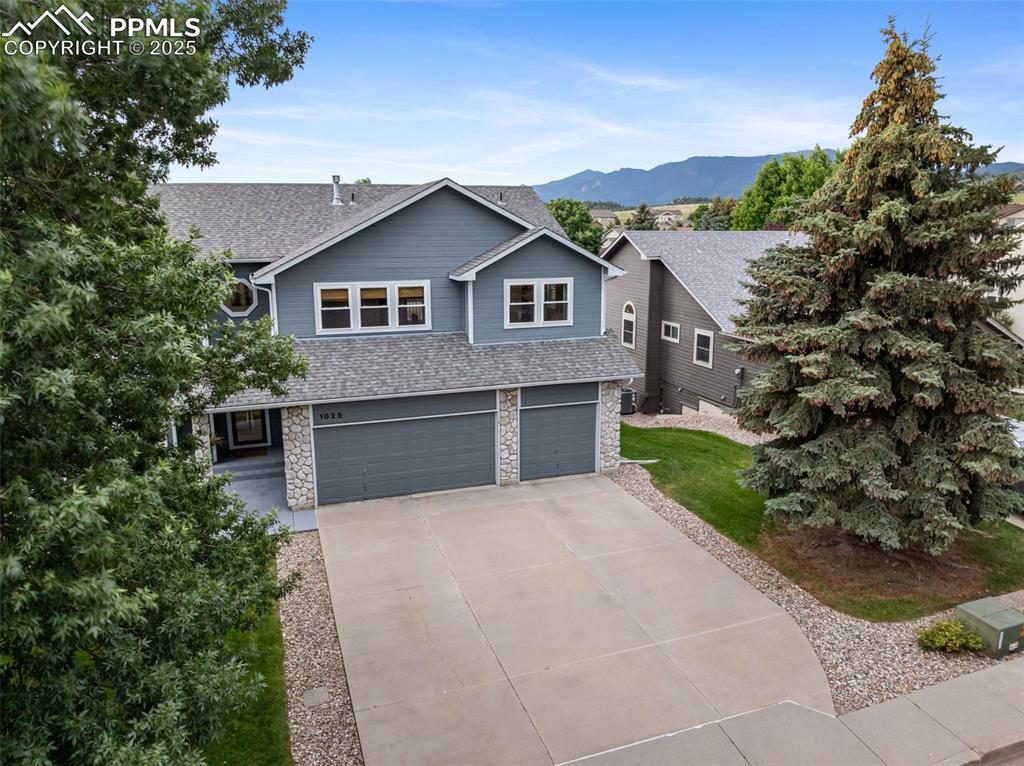 Image 37 of 44: Craftsman-style home with a garage, driveway, a mountain view, roof with sh
