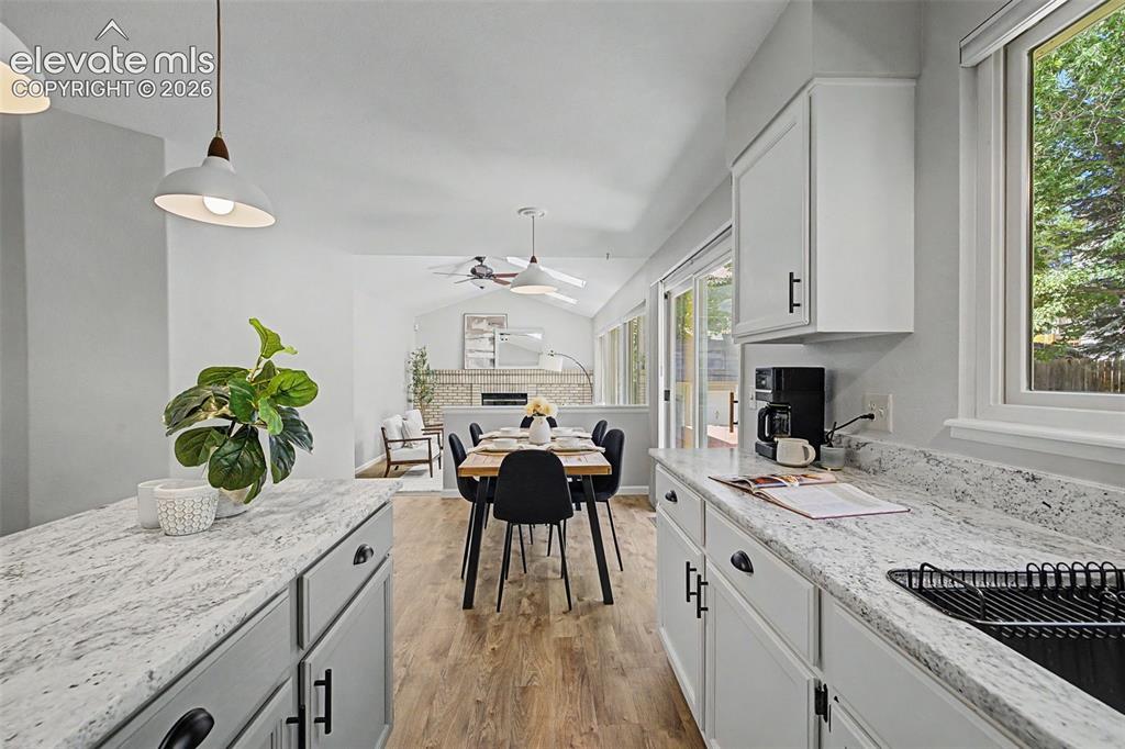 Image 24 of 49: Contemporary kitchen featuring a light-toned countertop, white cabinetry wi