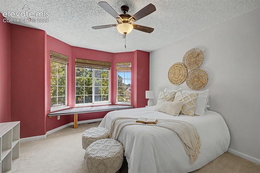 Image 37 of 49: Bay window with multiple large windows, wood-finish window blinds, and an i