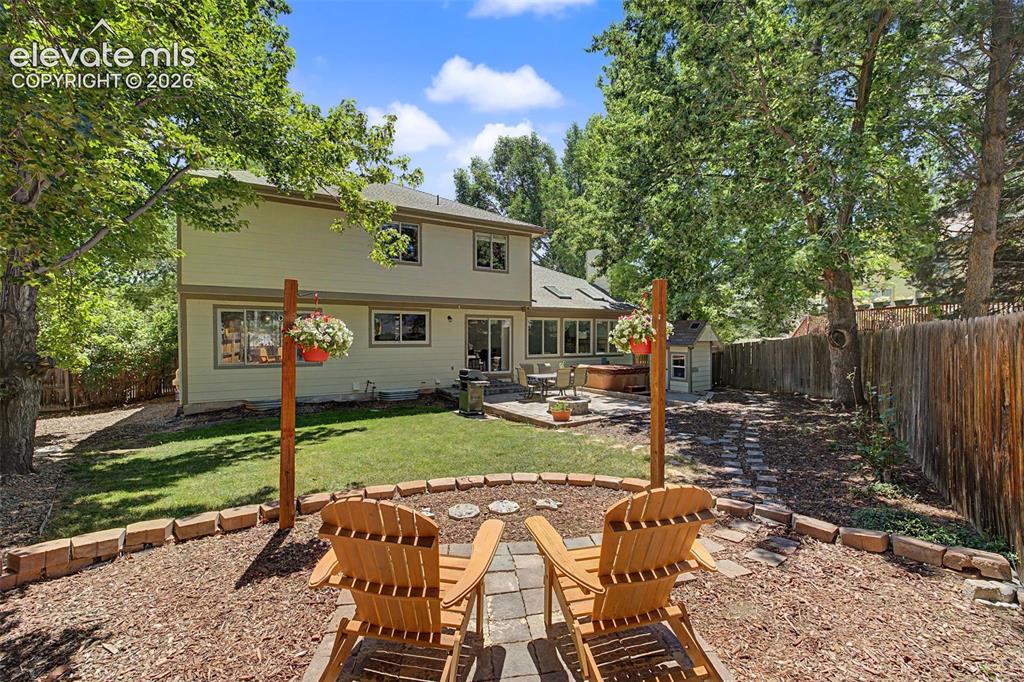 Image 42 of 49: Expansive backyard featuring a manicured lawn, established perimeter trees,
