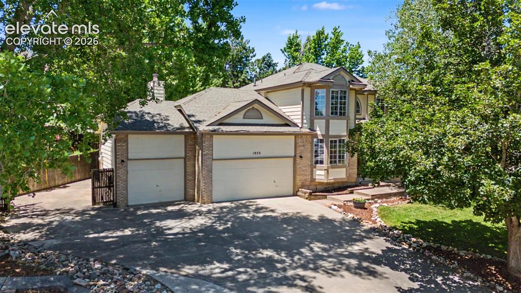 Image 49 of 49: Traditional two-story exterior with a two-car garage, bay windows, and a ma