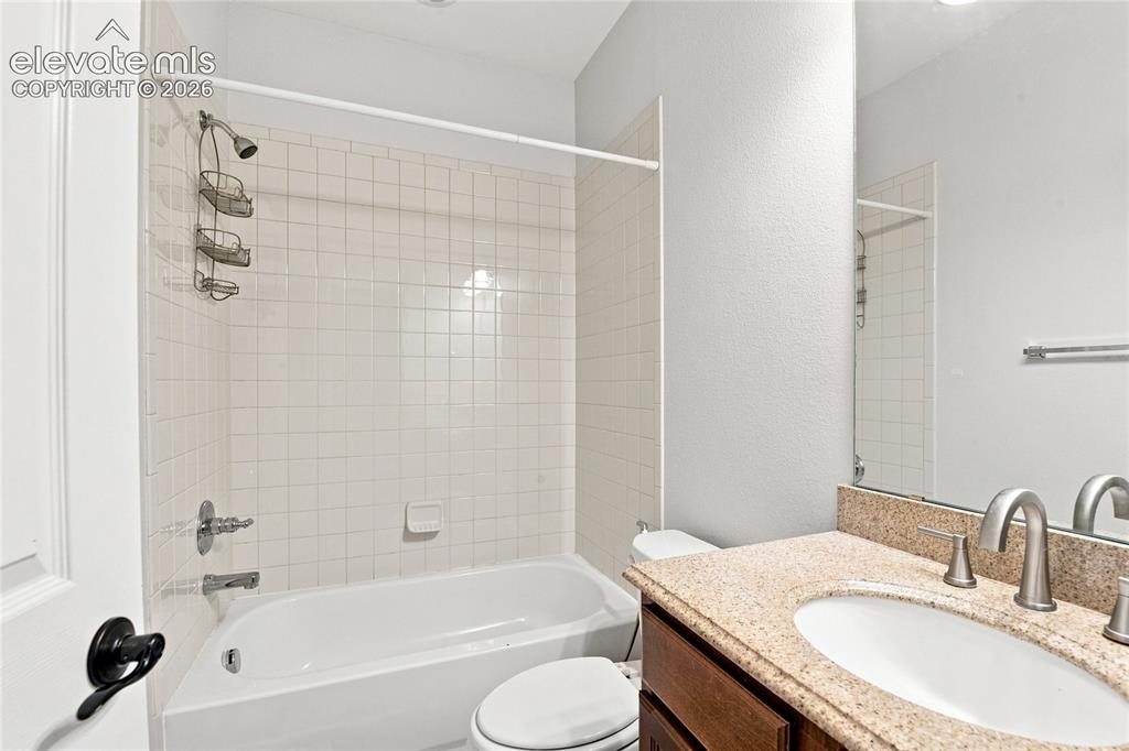 Image 10 of 18: Bathroom featuring a drop-in tub with tile surround, a built-in vanity with
