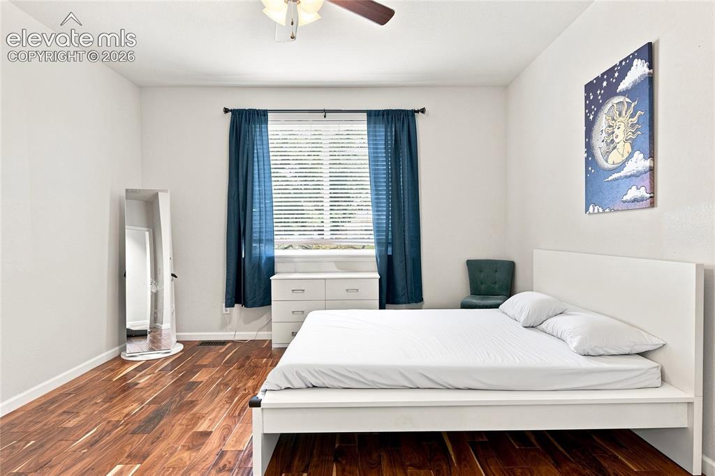 Image 7 of 18: Wood-finish flooring, ceiling fan with integrated lighting, window with bli