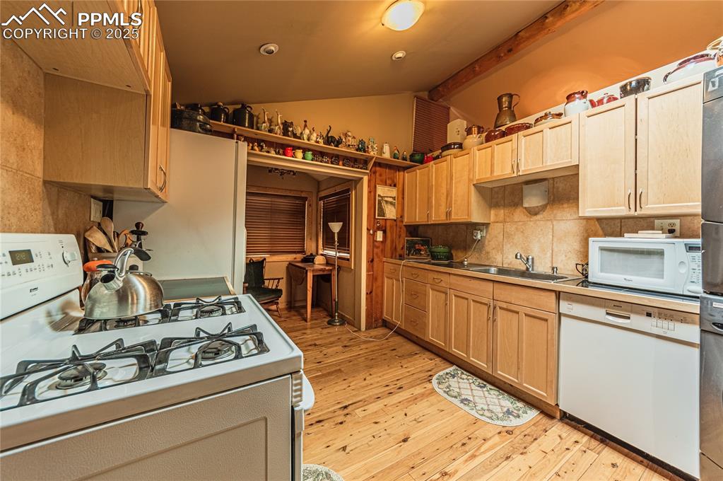 Image 6 of 23: Kitchen with white appliances, light brown cabinets, light wood-style floor