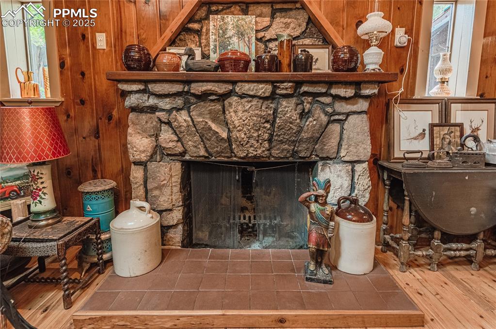 Image 7 of 23: Detailed view of wood walls, a fireplace, and wood finished floors