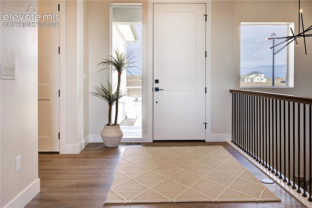 Image 6 of 35: Entryway featuring wood-finish flooring, a solid white door with dark hardw