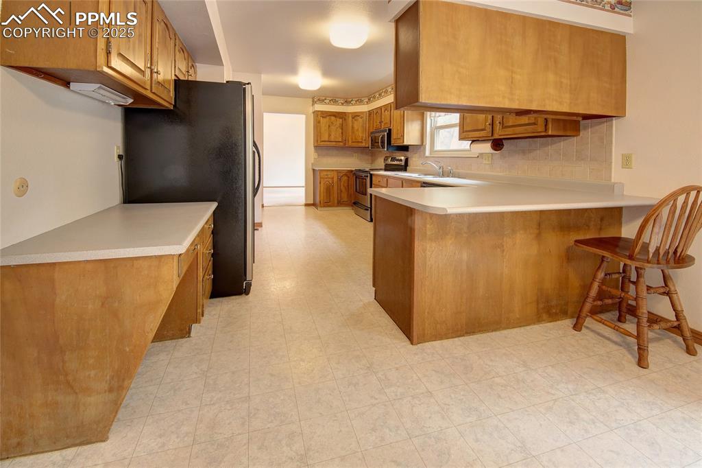 Image 13 of 48: Kitchen featuring work and sitting space 