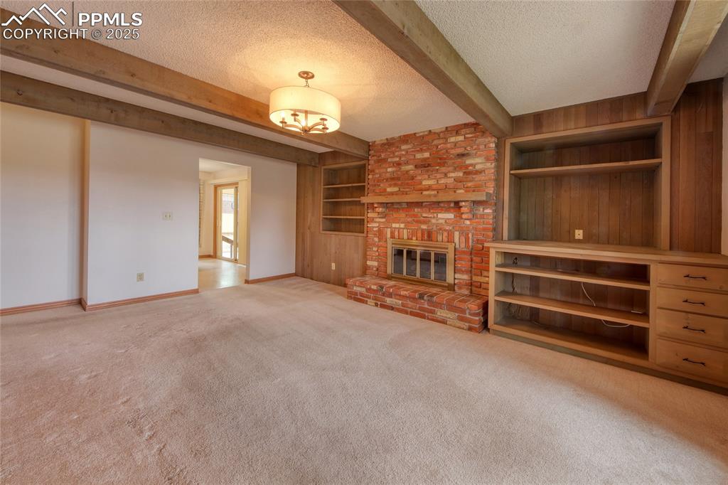 Image 18 of 48: Brick fireplace and built-ins for storage and decor