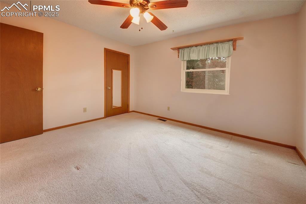 Image 24 of 48: Empty room featuring carpet, baseboards, and a ceiling fan