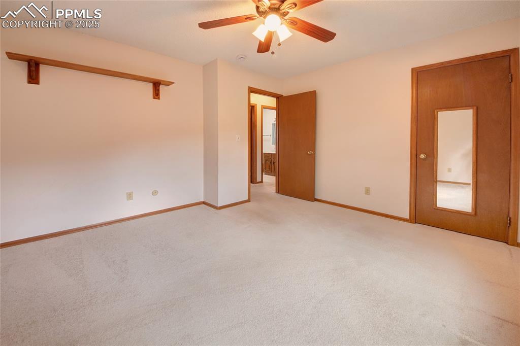 Image 25 of 48: Unfurnished room featuring light colored carpet, a ceiling fan, and baseboa
