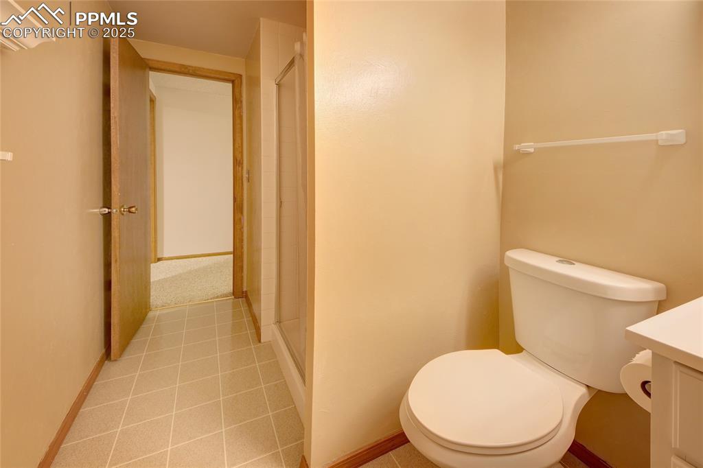 Image 33 of 48: Bathroom featuring toilet, a shower stall, vanity, and tile patterned floor
