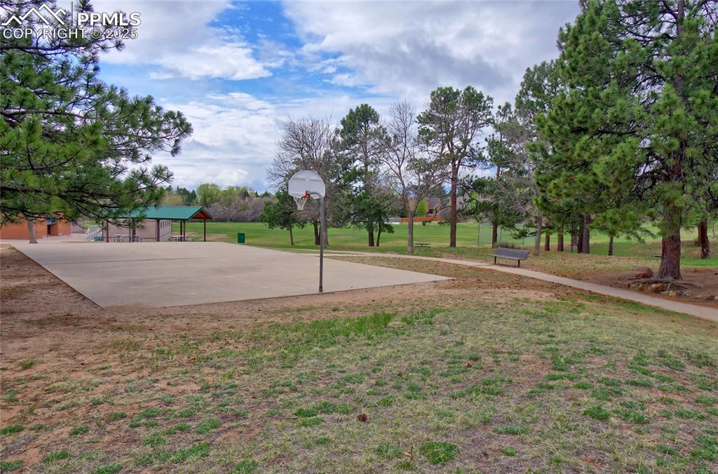 Image 40 of 48: View of sport court with a lawn and community basketball court