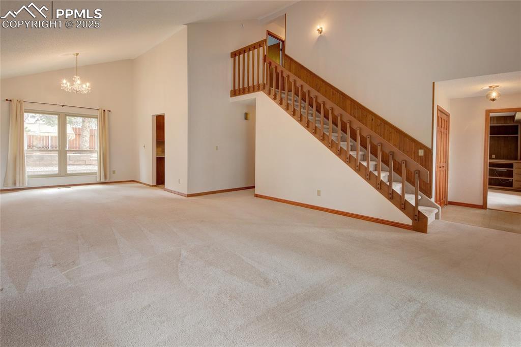 Image 6 of 48: Unfurnished living room with vaulted ceiling