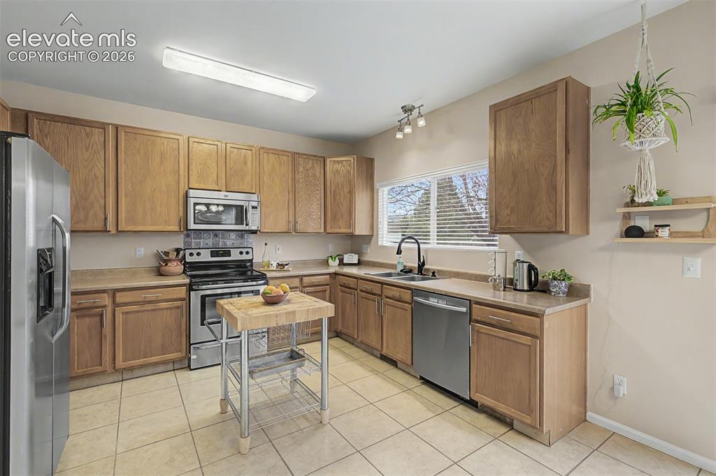 Image 12 of 45: Dining area with tile flooring and a patio door leading to an outdoor deck